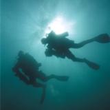 Technical scuba divers hovering through the deep waters Technical scuba divers hovering through the deep waters